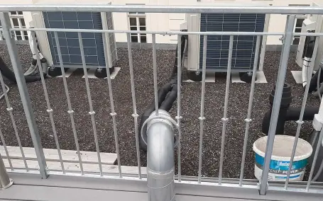 Detail eines verzinkten Stahlgeländers mit integrierter Dachentwässerung