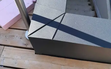 Maßgefertigte, pulverbeschichtete Metallverkleidung einer leicht erhöhten Mauer