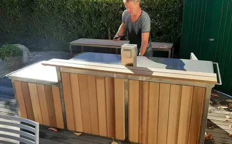 Outdoor-Küche mit Holzverkleidung und Edelstahl-Arbeitsfläche