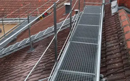 Verzinkter Dachsteg mit Sicherheitsgeländer auf Wiener Ziegeldach